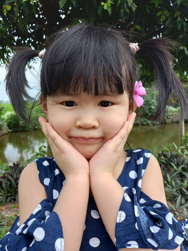 A child with pigtails in her hair

Description automatically generated