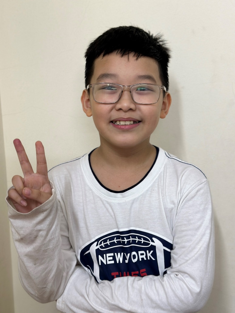 A child wearing glasses and holding up two fingers

Description automatically generated